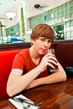 Boy drinks a soft drink with a straw by night Stock Photos
