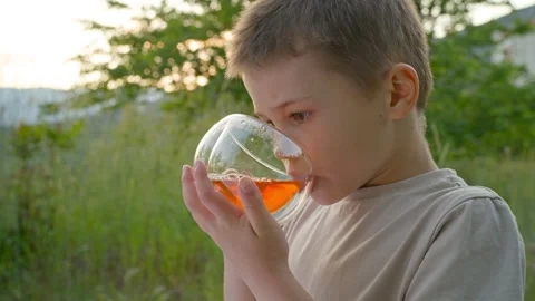 Boy drinks tea outside. Stock Footage 275746941