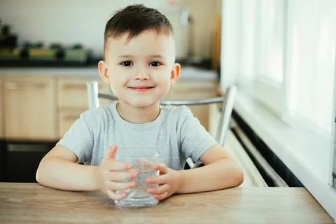 A boy drinks water in the kitchen Stock Photos