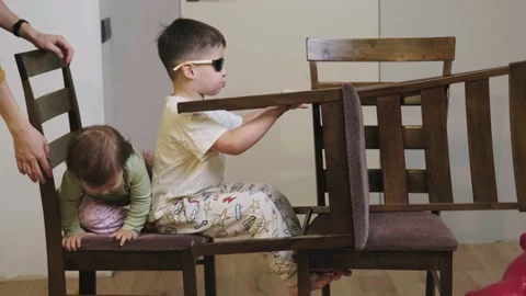 Boy driving in a makeshift car in the kitchen while wearing glasses and Stock Footage 172227325