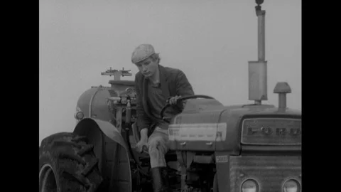 Boy driving tractor and spraying crops, man talking about being against that Stock Footage 141055499