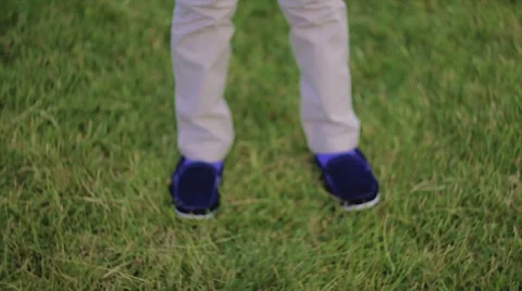 Boy Drops Ball on Grass in Front of Their Feet Stock Footage 64524030