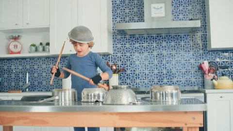 Boy Drumming in the kitchen using sticks Stock Footage 279245440