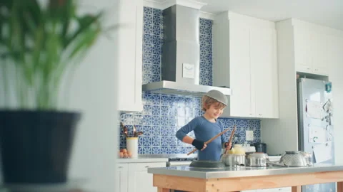 Boy Drumming in the kitchen using utensils Stock Footage 279245968
