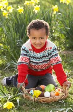 Boy on easter egg hunt in daffodil field Foto stock
