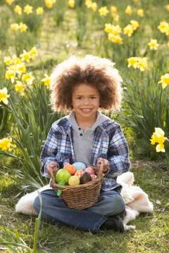Boy on easter egg hunt in daffodil field Stock Photos