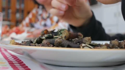 Boy eating barnacles with his hands Stock Footage 237526893