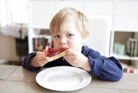 Boy eating bread and jam Stock Photos
