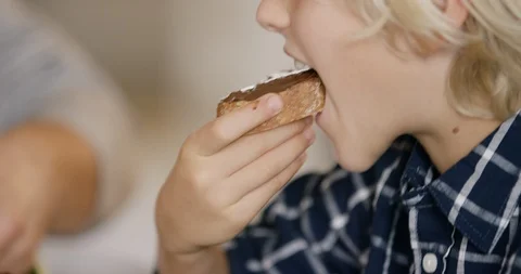 Boy Eating Bread With Chocolate Spread For Breakfast Stock Footage 125024699