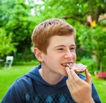 Boy eating a bread Stock Photos