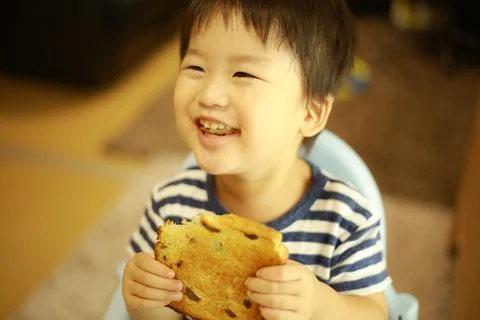 Boy eating bread Fotos Stock