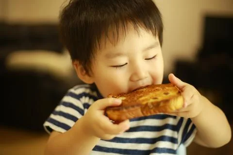 Boy eating bread Stock Photos