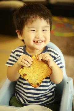 Boy eating bread Stock Photos