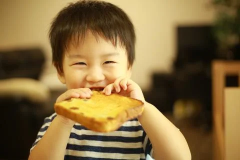 Boy eating bread Stock Photos