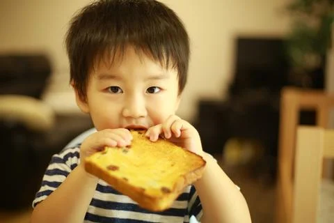 Boy eating bread Stock Photos