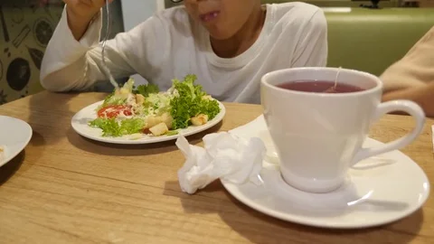A boy is eating Caesar salad by fork . 4k Stock Footage 81603513