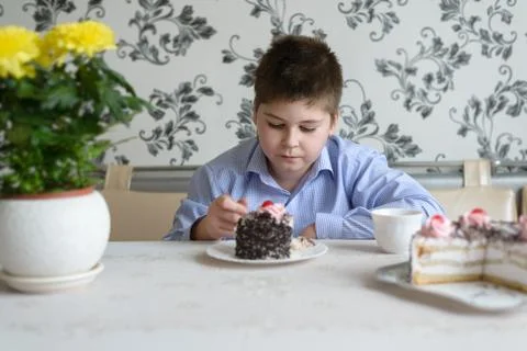 Boy eating cake at  table Stock Photos