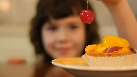 Boy eating cherry from top of cake. Boy stealing red cherry Stock Footage 125706657