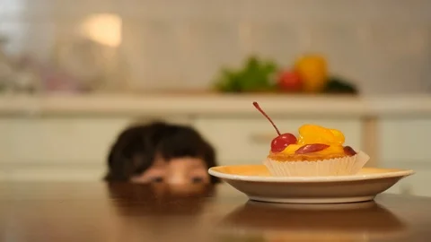 Boy eating cherry from top of cake. Boy stealing red cherry Stock Footage 125707090