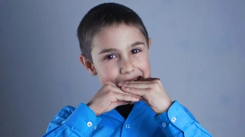 Boy eating chocolate and smiling. Nine-year-old boy eating sweet Stock Footage