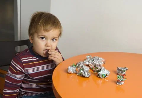 Boy eating chocolates Stock Photos