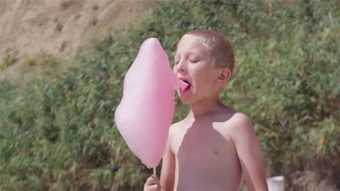 Boy eating cotton candy at the beach Stock Footage