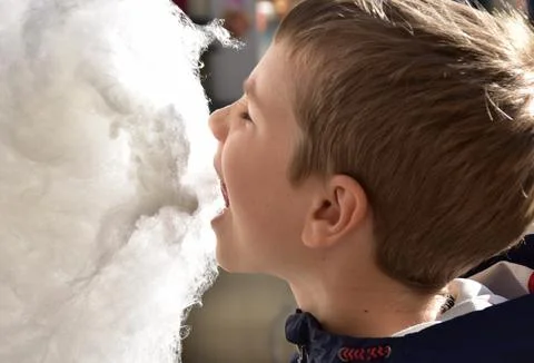 Boy eating cotton candy Stock Photos