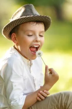 Boy is eating dandelion Stock Photos