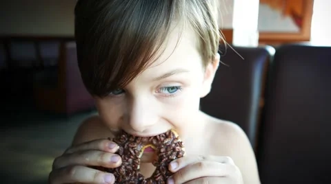 Boy eating a donut 库存影片 64628290