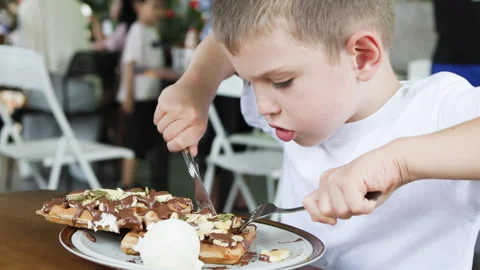 Boy eating fork and knife. Stock Footage 277198626