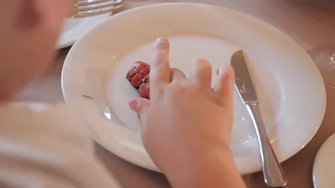 Boy eating a fork of red crayfish on a white plate Stock Footage 131360595