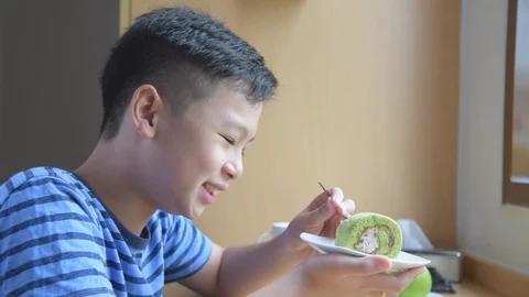 Boy eating green tea roll cake,slow motion. Stock Footage 108645795