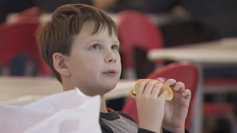 Boy eating a hamburger. close up, fast food Stock-Footage 113799164