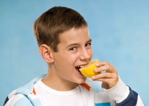 Boy Eating a Lemon Stock Photos