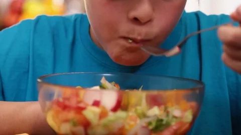 Boy eating mixed vegetables salad enjoying every bite Video stock 80104513