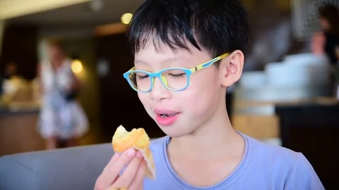 Boy eating muffin for breakfast Stock Footage 75521223