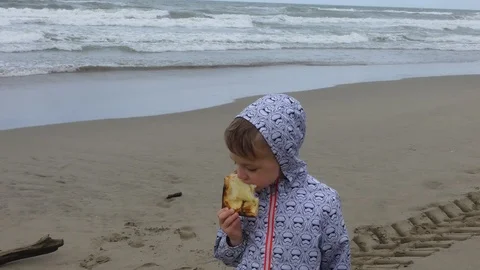 Boy eating pizza on the beach. Stock Footage 108465452