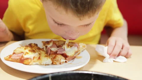 Boy eating pizza. Cheese stretch from mouth. Stock Footage 265146897