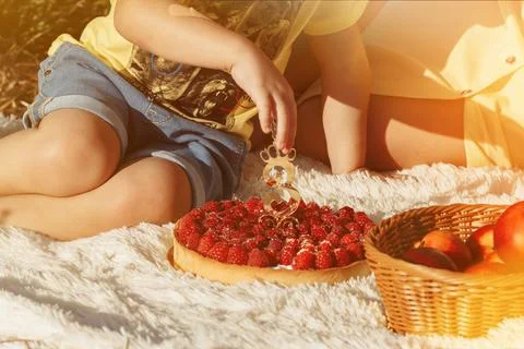Boy eating raspberry cake with number three Stock Photos