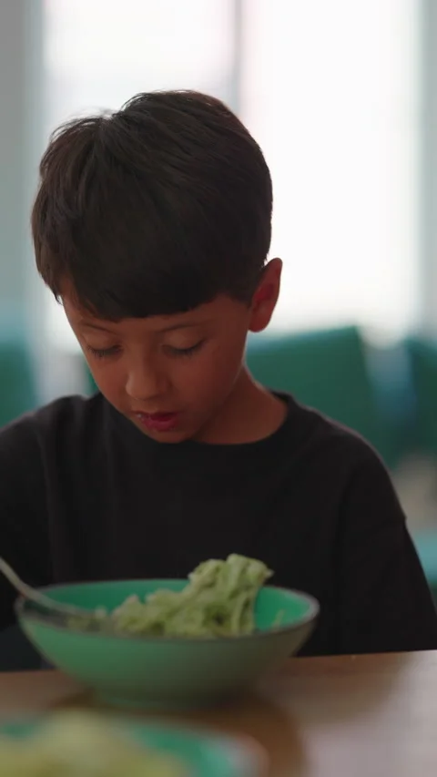 Boy eating spaghetti with fork at family table, enjoying healthy meal, inde.. Stock Footage 340449448