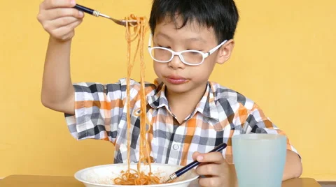 Boy eating spaghetti at home Stock Footage 64834496