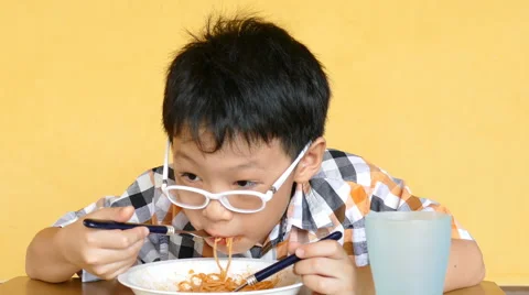 Boy eating spaghetti at home Stock Footage 64834627