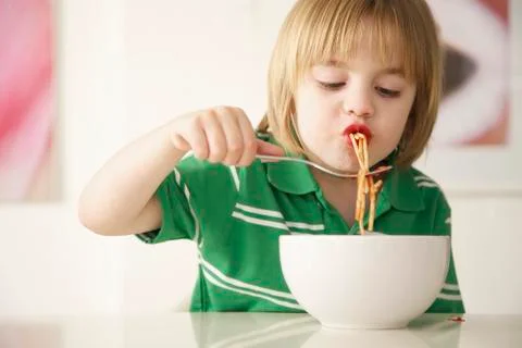 A boy eating spaghetti Stock Photos