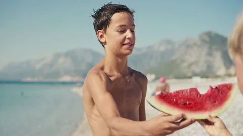 Boy eating watermelon on the beach, summertime Stock Footage 200655565
