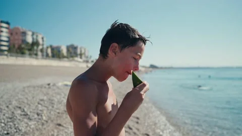 Boy eating watermelon on the beach, summertime 스톡 동영상 201145544