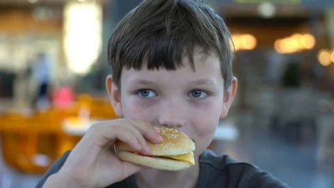 Boy eats a black burger close up. Video stock 78197983