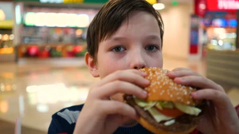 Boy eats a burger close up. Stock Footage 87095703