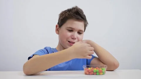 Boy eats candy on white background Stock Footage 241517061