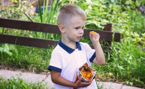 A boy eats chips in the park. Selective focus Stock Photos