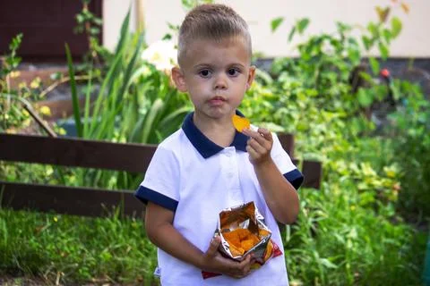 A boy eats chips in the park. Selective focus Stock Photos